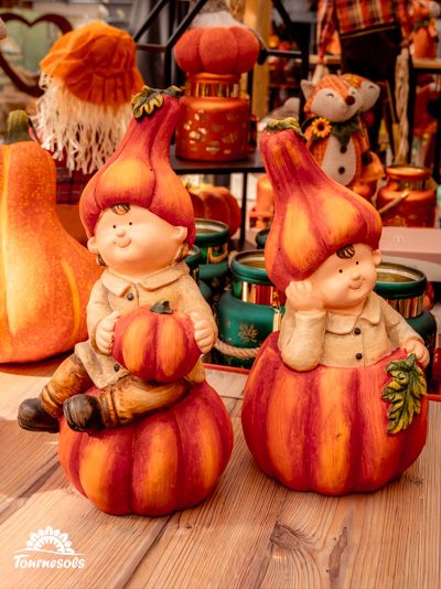Figurines d'enfants en citrouilles dans un décor automnal chaleureux.